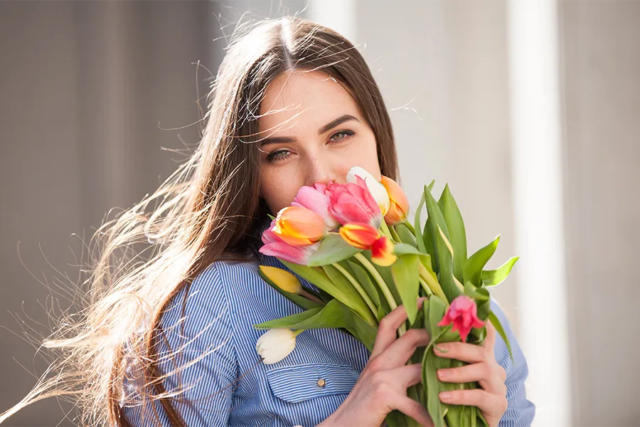 Жена, държаща голям букет цветя