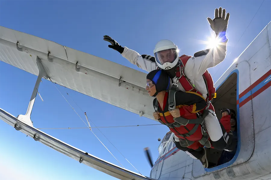 хора, които скачат с парашут от самолет